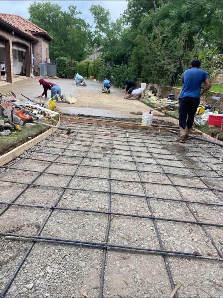 Crew pouring concrete over a rebar grid